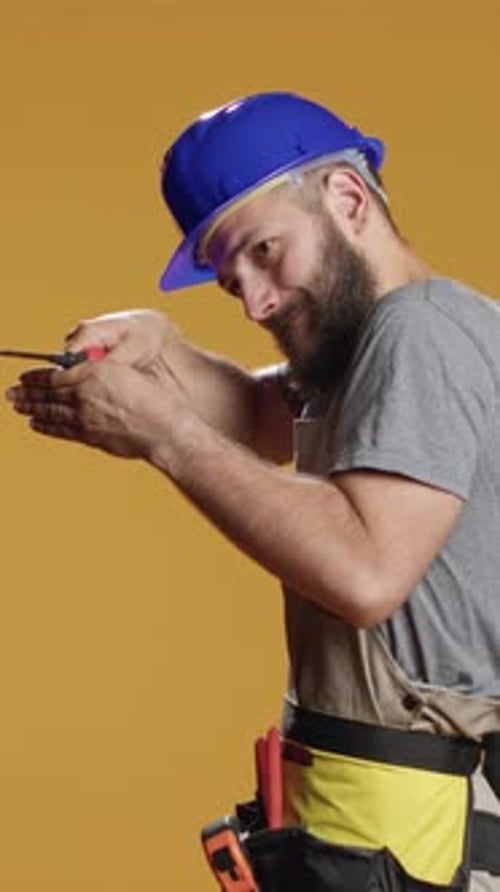 Vertical Video Industrial Repairman Working with Screwdriver to Turn Nails and Bolts