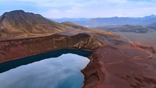 Water filling the crater of sleeping volcano. Bare mountainous landscape with no vegetation.