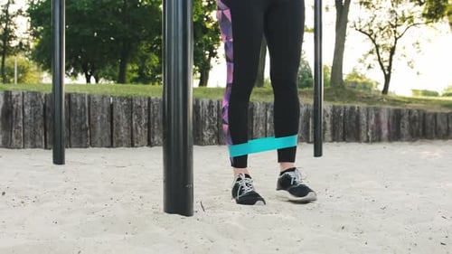 Woman Exercising Legs with Resistance Band Outdoors