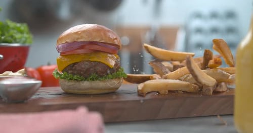 Knusprige Pommes frites neben saftigem Cheeseburger auf einem Teller mit Sauce