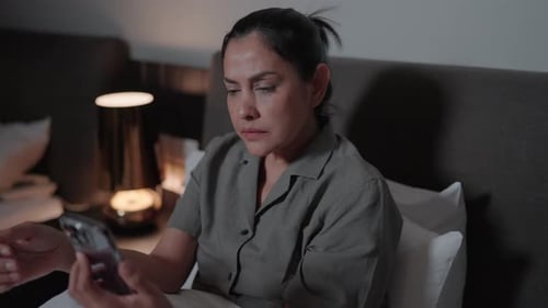 Woman Using Smartphone in Bed at Night