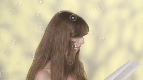 Appealing Brunette Girl Lreading a Book and Many Small Soap Bubbles Flying Around Her Slow Motion