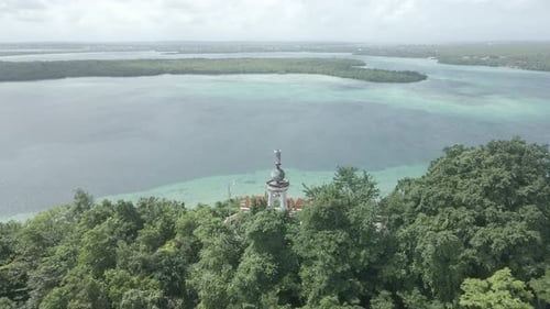 Vista aérea de la estatua de Jesús con hermosa vista a la playa en la isla de Molucas, Indonesia