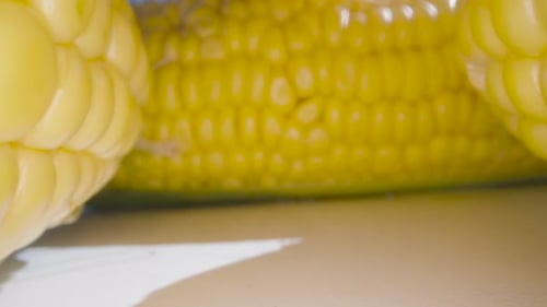 Big juicy corn on the table. Summer, sun, blue sky. Dolly slider extreme close-up. Laowa Probe. Slow