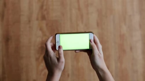 People and Technology Concept - Hands Holding Smartphone with Chroma Key Green
