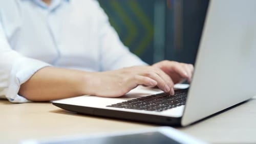 Close up hands of asian male employee working on laptop computer in modern office. Man Typing
