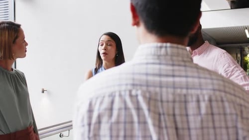 Discussing project details, diverse business team collaborating in modern office