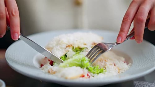 Woman eating Caesar salad at a restaurant