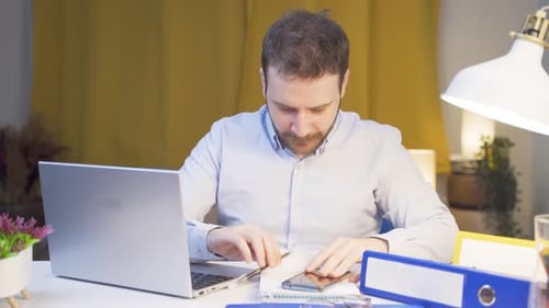 Home office worker man working on laptop stressed.