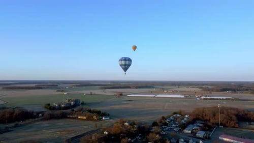 Breathtaking View of Hot Air Balloons Over Farmland