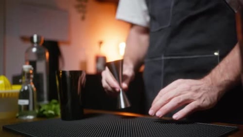 Hausmixologe präsentiert seine Ausrüstung. Zeigt Jigger in Zeitlupe
.