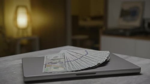Laptop with Stack of US Hundred Dollar Bills