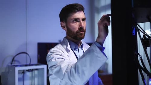 Man in Lab Coat Operating High Tech Equipment