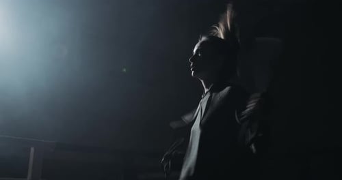 Woman Exercises Skipping Rope in Dark Gym