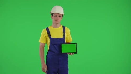 Medium Green Screen Isolated Chroma Key Video of a Young Construction Worker Pointing at the Tablet