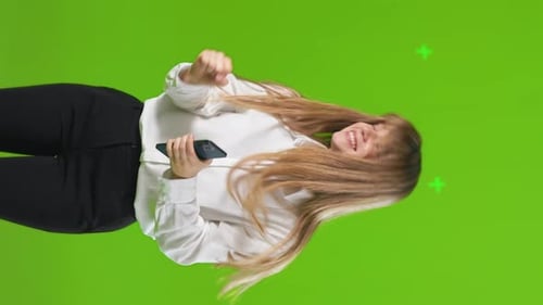 Happy Woman with Smartphone Dancing and Having Fun in Studio