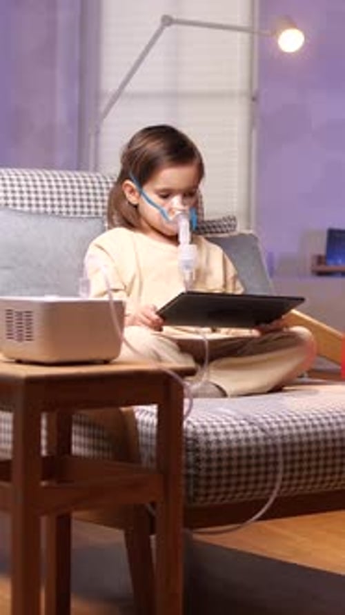 Child Using Oxygen Machine and Tablet at Home