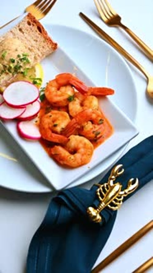 Crevettes en sauce sur plaque blanche. Crevettes à la sauce à l'orange soigneusement disposées sur une assiette blanche éclatante
.