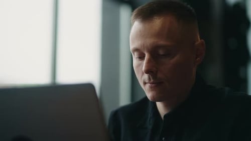Young Man Working on Laptop Computer Indoors