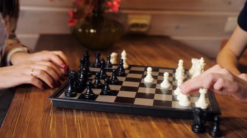 Eine Frau und ihre Tochter spielen Schach in der Küche