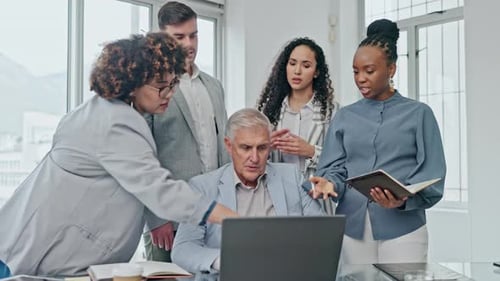 Colleagues Collaborating Around Laptop in Bright Modern Office
