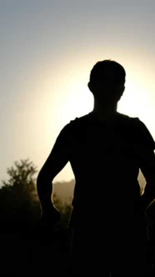 Silhouette Person Arms Raised at Sunset