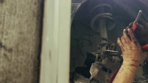 Mechanic Repairing Car Brakes in an Automotive Shop