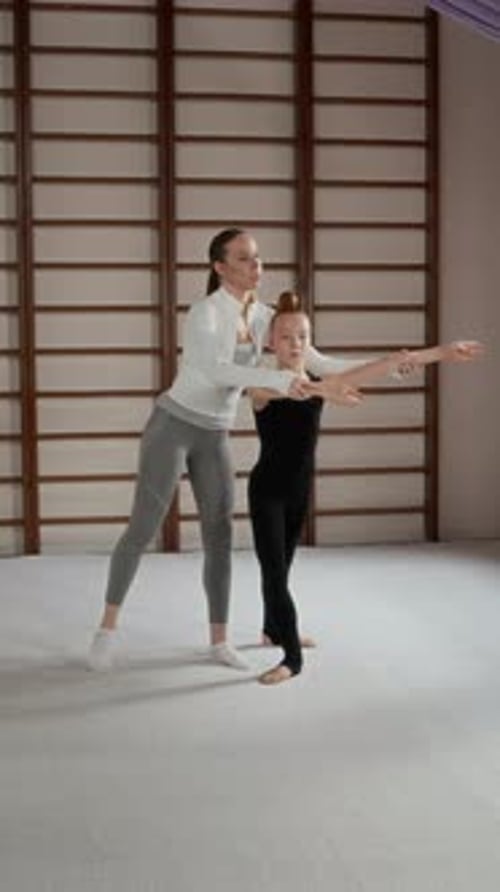 Gymnast Balances With Help From Coach