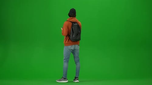 Portrait of Traveler Isolated on Chroma Key Green Screen Background Young Man with Backpack Checking