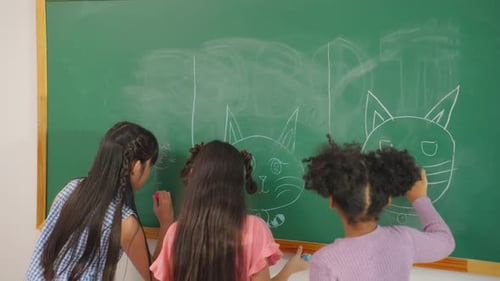Diverse student writing blackboard in classroom at elementary school.