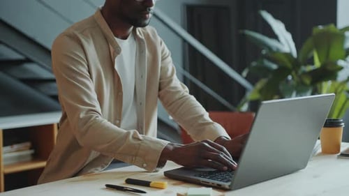 African American Businessman Typing on Laptop at Office Workplace