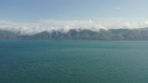 Drone aérien d'une mer calme avec des montagnes brumeuses