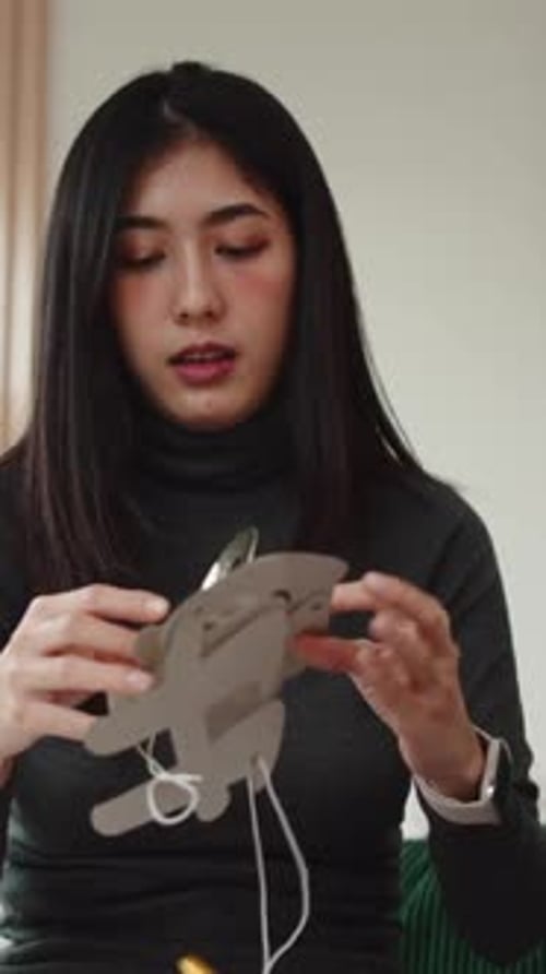 Woman Stringing Together Pieces to Make Happy Sign