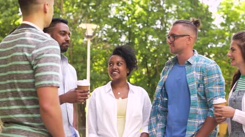 Friends Socializing with Coffee in a Sunny Park
