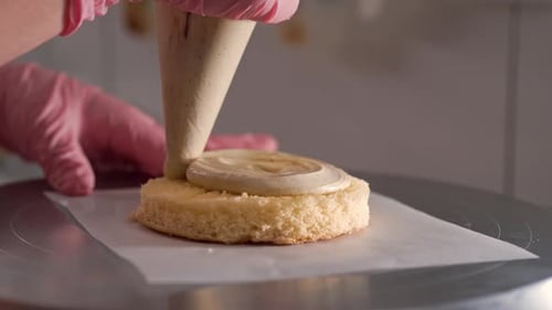 Pastry Chef Decorates Cake with Frosting
