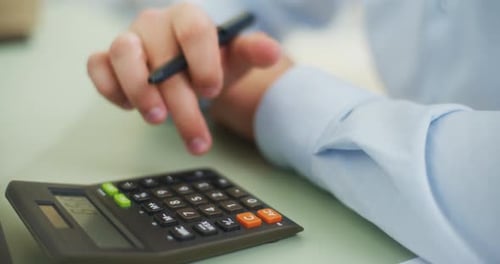 Man Using Calculator in Office Close Up