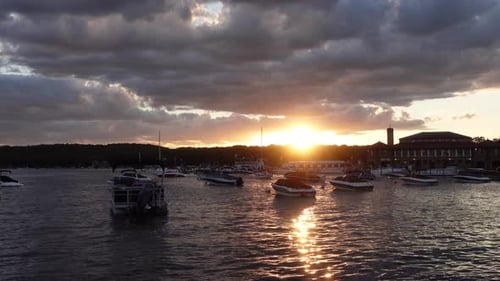 Dramático atardecer con barcos en el agua, tarde nublada