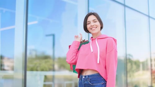 Young Woman Smiling with Shopping Bags in Urban Setting