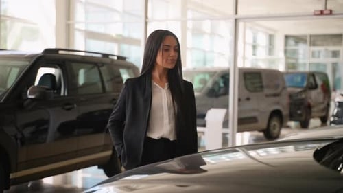 Elegant Saleswoman Posing Near Car in Dealership