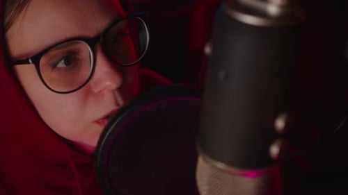 Woman Speaks into Microphone in Soft Light at Night