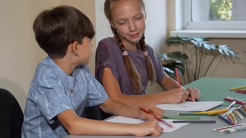 Two Children Drawing Together with Colored Pencils