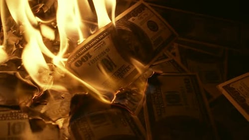 Ein Haufen brennender US-Dollar verwandelt sich in Asche aus nächster Nähe und symbolisiert die Zerstörung von Wohlstand und