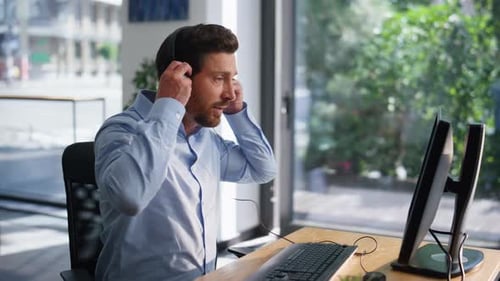 Callcenter-Mitarbeiter sitzen im Büro, tragen Kopfhörer, Nahaufnahme, Mann, Bediener