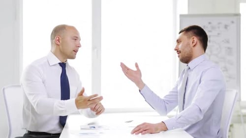 Serious businessmen discussing finances and corporate papers in the office