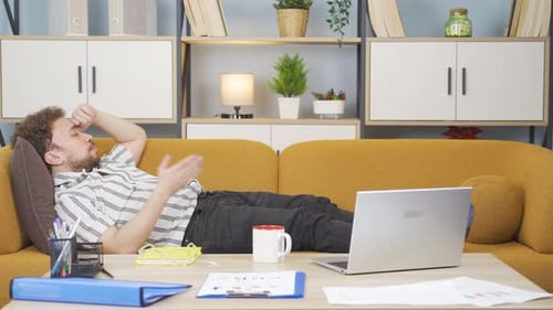 Man Relaxing on Couch with Laptop