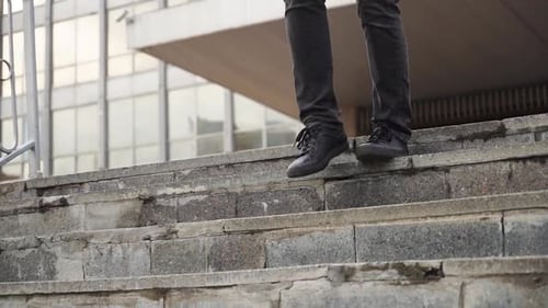 A Young Man Walks Down the Steps in Black Sneakers City