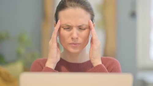 Close Up of Beautiful Woman having Headache while Working on Laptop