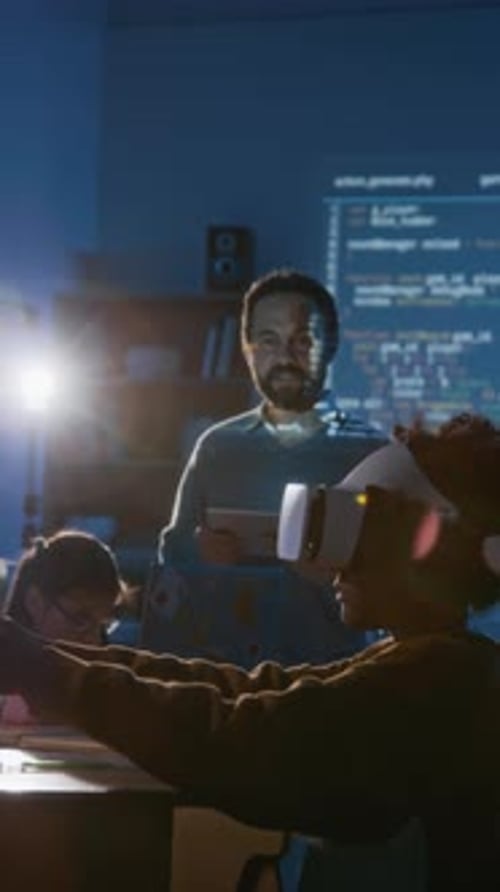 Мальчик в гарнитуре виртуальной реальности просматривает учебник на уроке программирования