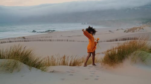 Mujer bajando la colina agitando la mano, tarde de verano