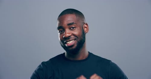 Smiling Young Man Makes Heart with Hands